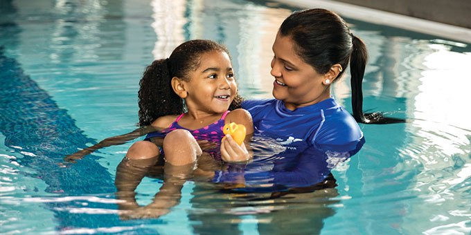 Swim instructor with child in pool