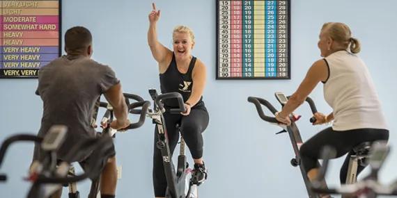 three people on exercise bikes