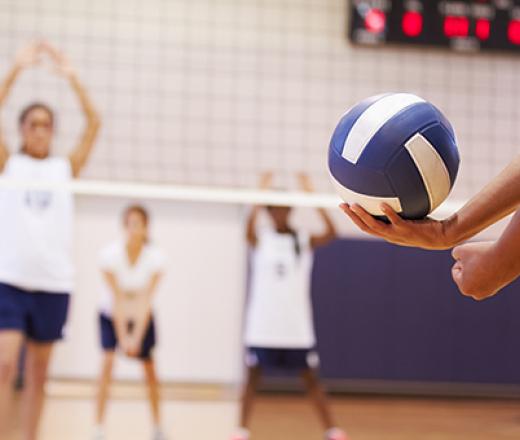 someone serving a blue volleyball