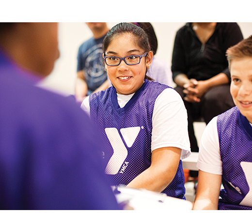 Child being taught basketball by instructor