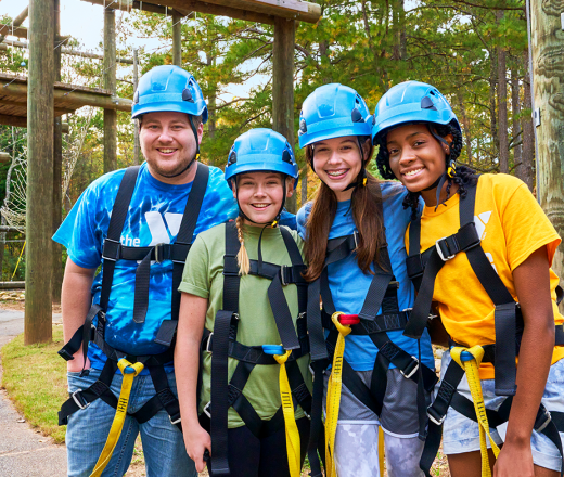 group of kids and a counselor doing a challenge course